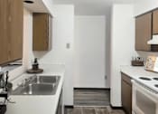 Thumbnail 2 of 7 - A modern kitchen with a white countertop and brown cabinets.