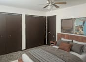Thumbnail 4 of 7 - A bedroom with a bed, pillows, and a ceiling fan.