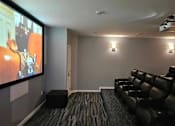 Thumbnail 15 of 24 - a living room with a large screen tv and leather couches