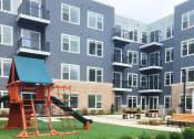 Thumbnail 20 of 39 - a playground in front of an apartment building