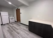 Thumbnail 15 of 19 - A kitchen area with a white fridge, a white oven, and a wooden door.