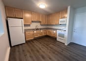 Thumbnail 3 of 19 - A kitchen with wooden cabinets and a white refrigerator.