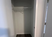 Thumbnail 6 of 19 - Empty white hallway with a shelf on the wall.