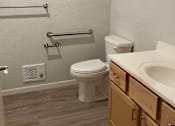 Thumbnail 9 of 15 - A white toilet sits next to a sink in a bathroom.