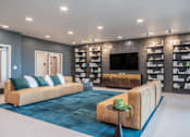 Thumbnail 16 of 54 - A living room with a large couch and a television.