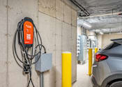 Thumbnail 19 of 54 - A grey car is parked next to a charging station.