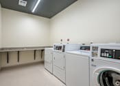 Thumbnail 14 of 54 - A row of washing machines in a laundry room.