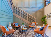 Thumbnail 24 of 80 - A living room with a staircase and a couch.