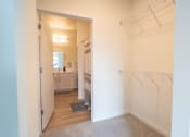 Thumbnail 10 of 39 - a walk in closet with clothes rails and a bathroom with a sink and a mirror