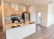 Thumbnail 2 of 39 - a kitchen with a large island and a stainless steel refrigerator