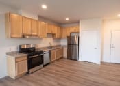 Thumbnail 6 of 39 - an empty kitchen with wooden cabinets and stainless steel appliances