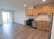 Thumbnail 5 of 39 - a kitchen and living room with wood flooring and wooden cabinets