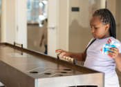Thumbnail 18 of 39 - a little girl playing with a toy at a counter