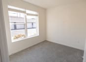 Thumbnail 9 of 39 - an empty bedroom with a large window and carpeting