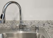 Thumbnail 7 of 39 - a kitchen sink with a faucet and a marble counter top
