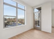 Thumbnail 12 of 80 - A room with a large window overlooking a parking lot.