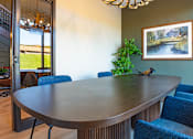 Thumbnail 34 of 80 - A dining room with a round table and blue chairs.