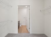 Thumbnail 18 of 80 - A white hallway with a doorway leading to a bathroom.