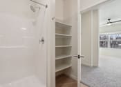 Thumbnail 20 of 80 - A white bathroom with a walk in shower and a white door.