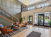 Thumbnail 25 of 80 - A lobby with a staircase and a glass door.