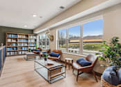 Thumbnail 27 of 80 - A living room with a large window, a bookshelf, and a leather chair.
