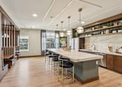 Thumbnail 33 of 80 - A modern kitchen with a large island and bar stools.