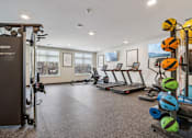 Thumbnail 26 of 80 - A gym with a variety of equipment including treadmills, weights, and a squat rack.