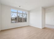 Thumbnail 10 of 80 - Empty room with a large window and wooden flooring.