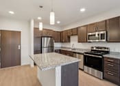 Thumbnail 4 of 80 - A kitchen with a granite countertop and stainless steel appliances.