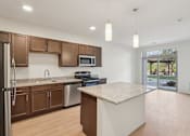 Thumbnail 6 of 80 - A kitchen with a refrigerator, microwave, oven, and sink.