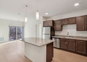Thumbnail 5 of 80 - A kitchen with brown cabinets and a granite countertop.