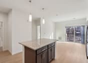 Thumbnail 9 of 80 - A kitchen with a granite countertop and wooden cabinets.