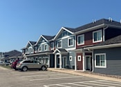 Thumbnail 1 of 30 - A row of houses with cars parked in front.