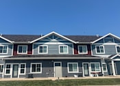 Thumbnail 25 of 30 - A row of houses with grey and red trim.