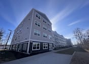 Thumbnail 15 of 15 - a three story apartment building with a sidewalk in front of it