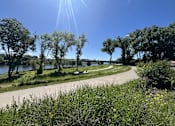 Thumbnail 19 of 20 - a path through a park next to a river