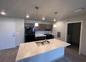Thumbnail 3 of 13 - a kitchen with a large island and a black refrigerator