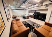 Thumbnail 10 of 13 - a living room with couches and a kitchen in the background