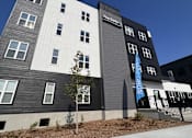 Thumbnail 1 of 13 - a gray and white building with a blue sky in the background