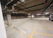 Thumbnail 13 of 13 - a parking garage with a car parked on the side of the road
