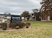Thumbnail 1 of 36 - A sign for Woodside Terrace Apartment Homes is displayed in front of a grassy area.