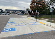 Thumbnail 34 of 36 - A parking lot with a blue and white handicap parking space.