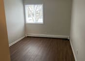 Thumbnail 12 of 36 - A room with a window and a wooden floor.