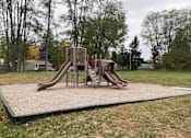 Thumbnail 28 of 36 - A playground with a slide and a swing set.