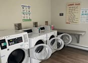 Thumbnail 22 of 36 - A laundry room with washing machines and a laundry rules sign.