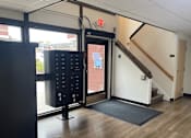 Thumbnail 5 of 36 - A black door with a keypad and a red exit sign above it.