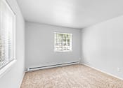 Thumbnail 12 of 25 - A room with a window and carpeted floor.