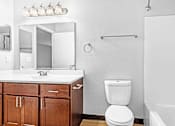 Thumbnail 16 of 25 - A white toilet sits next to a sink in a bathroom.