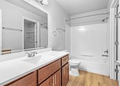Thumbnail 15 of 25 - A white bathroom with a white sink and toilet.