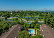 Thumbnail 25 of 25 - A bird's eye view of a residential area with houses, a swimming pool, and a lake.